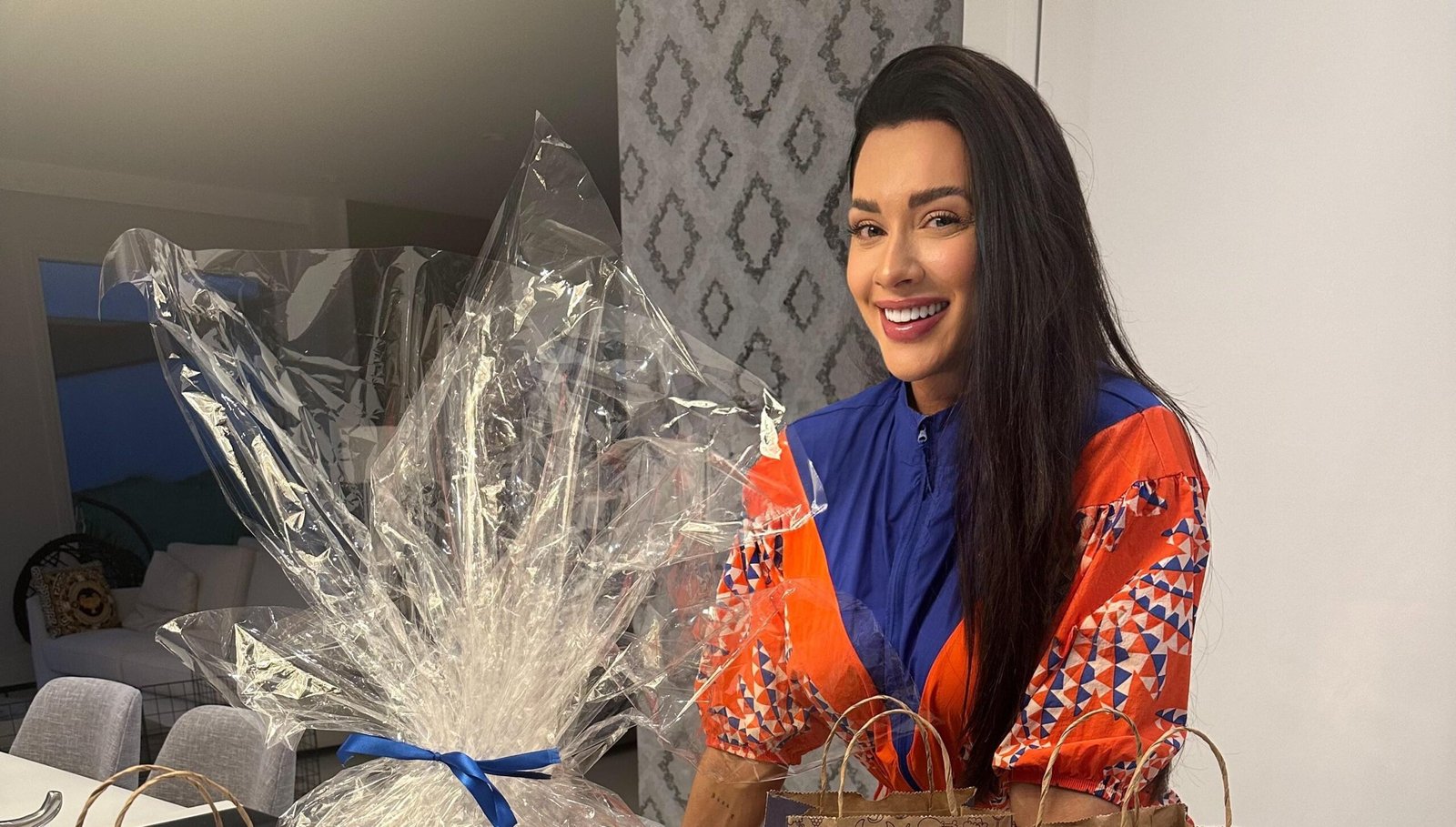 Juju Salimeni sorrindo ao lado de kits de lanches embalados da Bonaliment